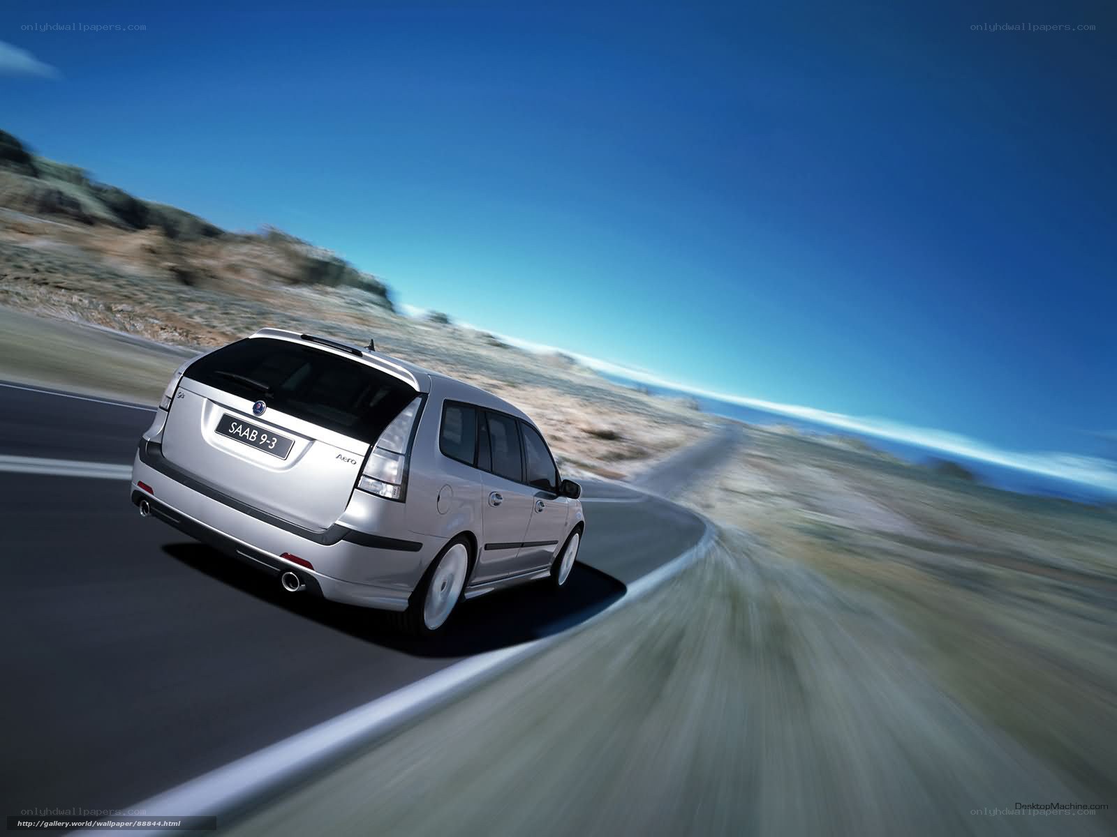 silver saab 9-3 driving on coastal road