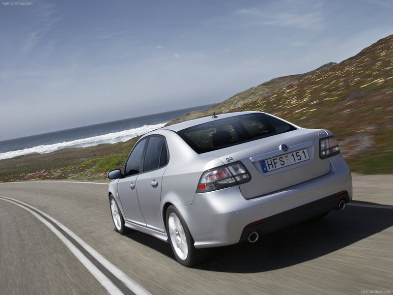 silver saab driving on coastal road