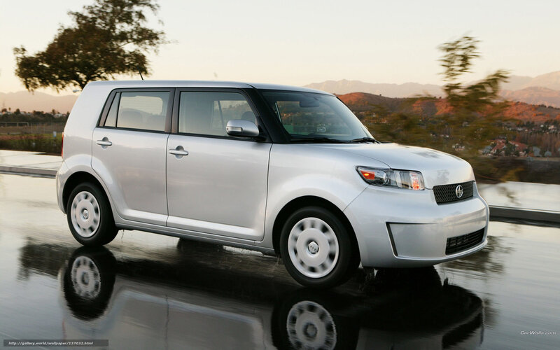 silver scion xB driving on wet road