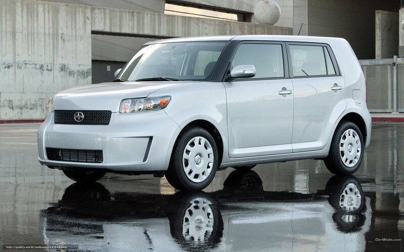 silver scion xB parked on wet pavement
