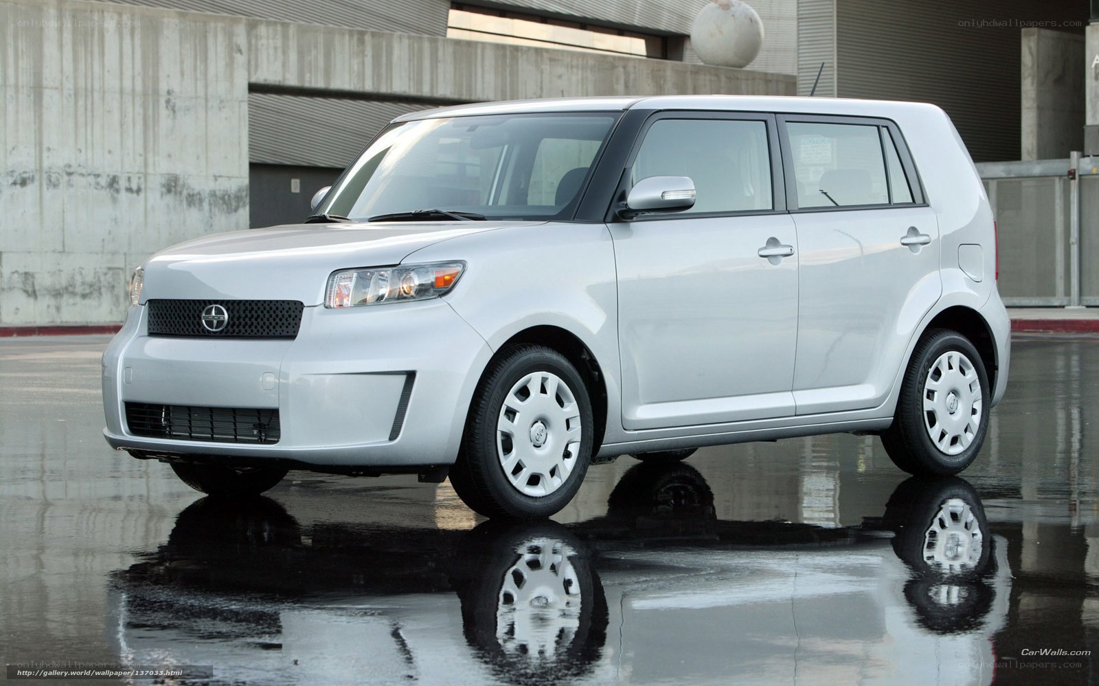 silver scion xB parked on wet pavement