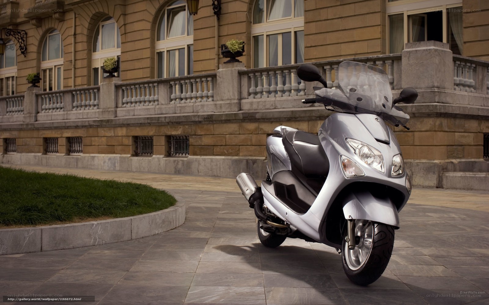 Silver scooter in front of building