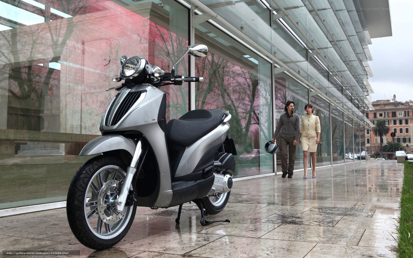 Silver scooter on wet sidewalk