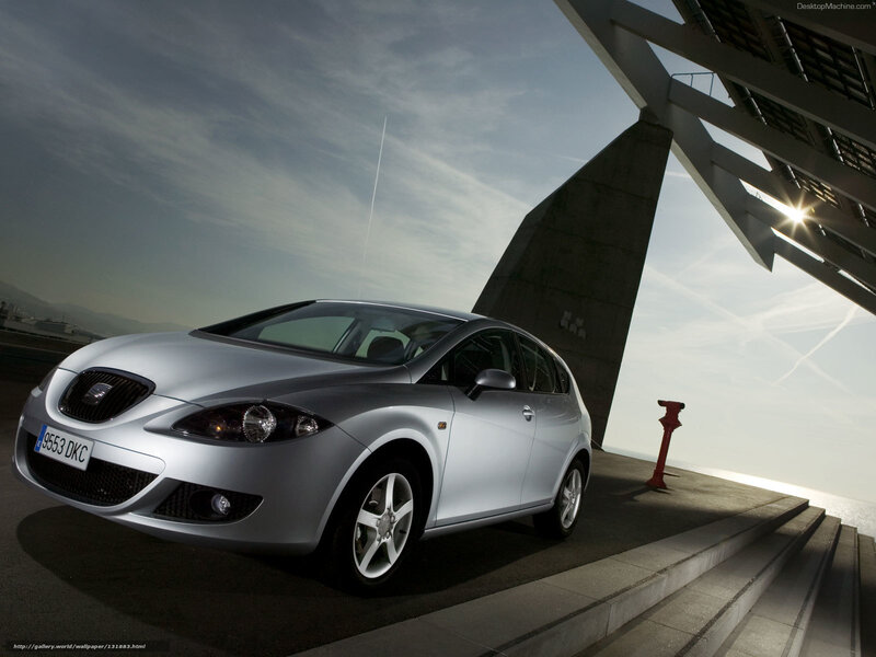 Silver SEAT Leon parked near modern structure