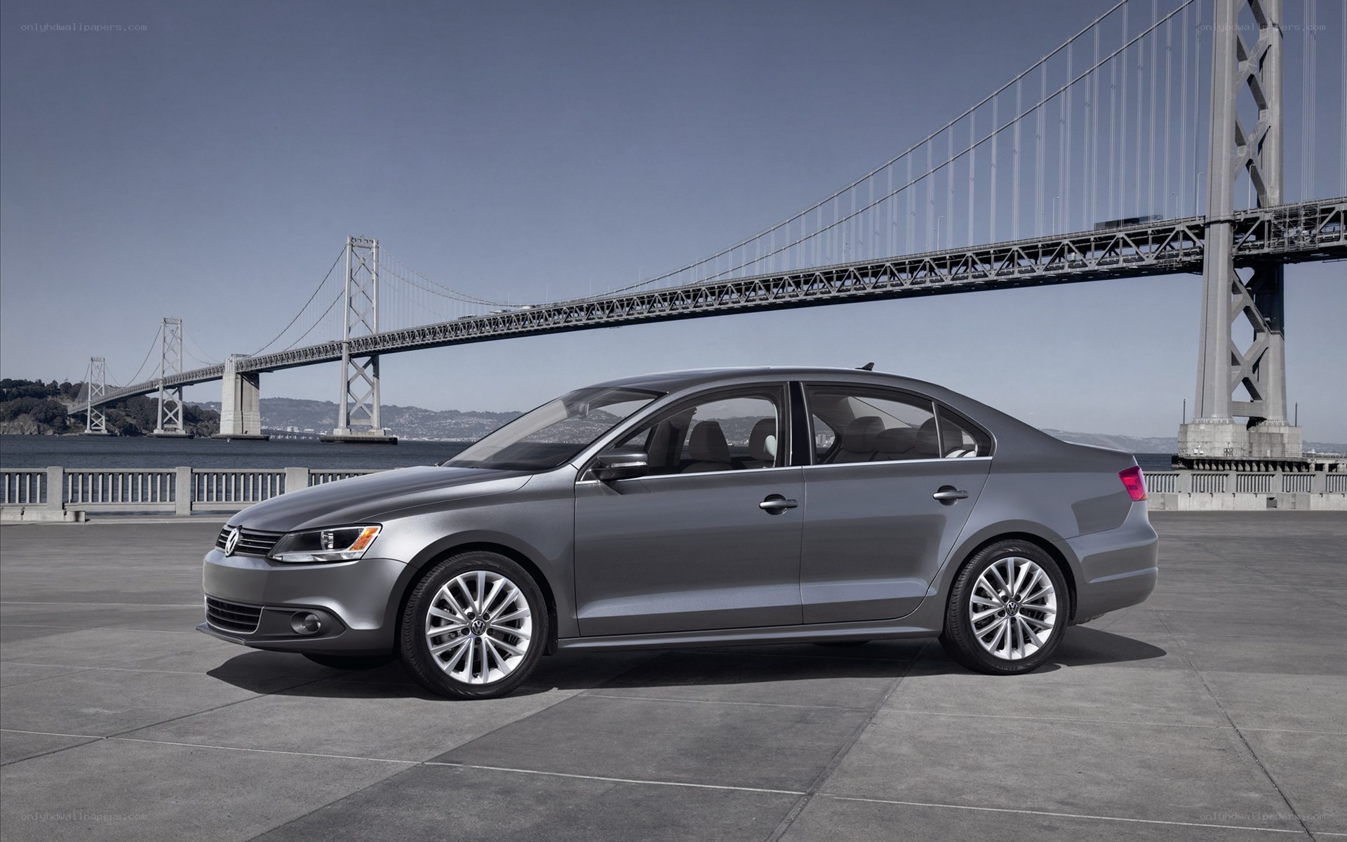 Silver sedan by a bridge