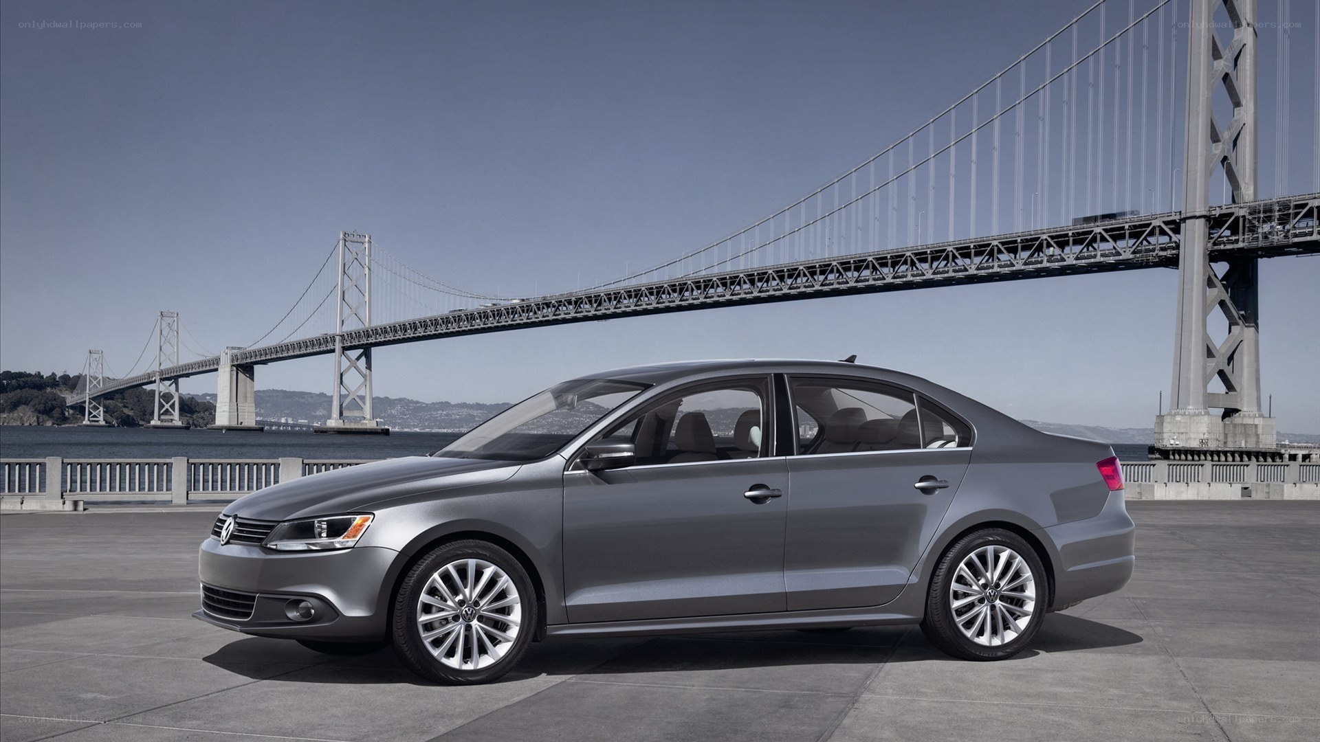 Silver sedan by a bridge