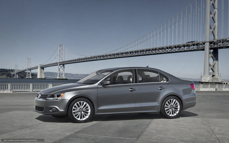 Silver sedan by a bridge