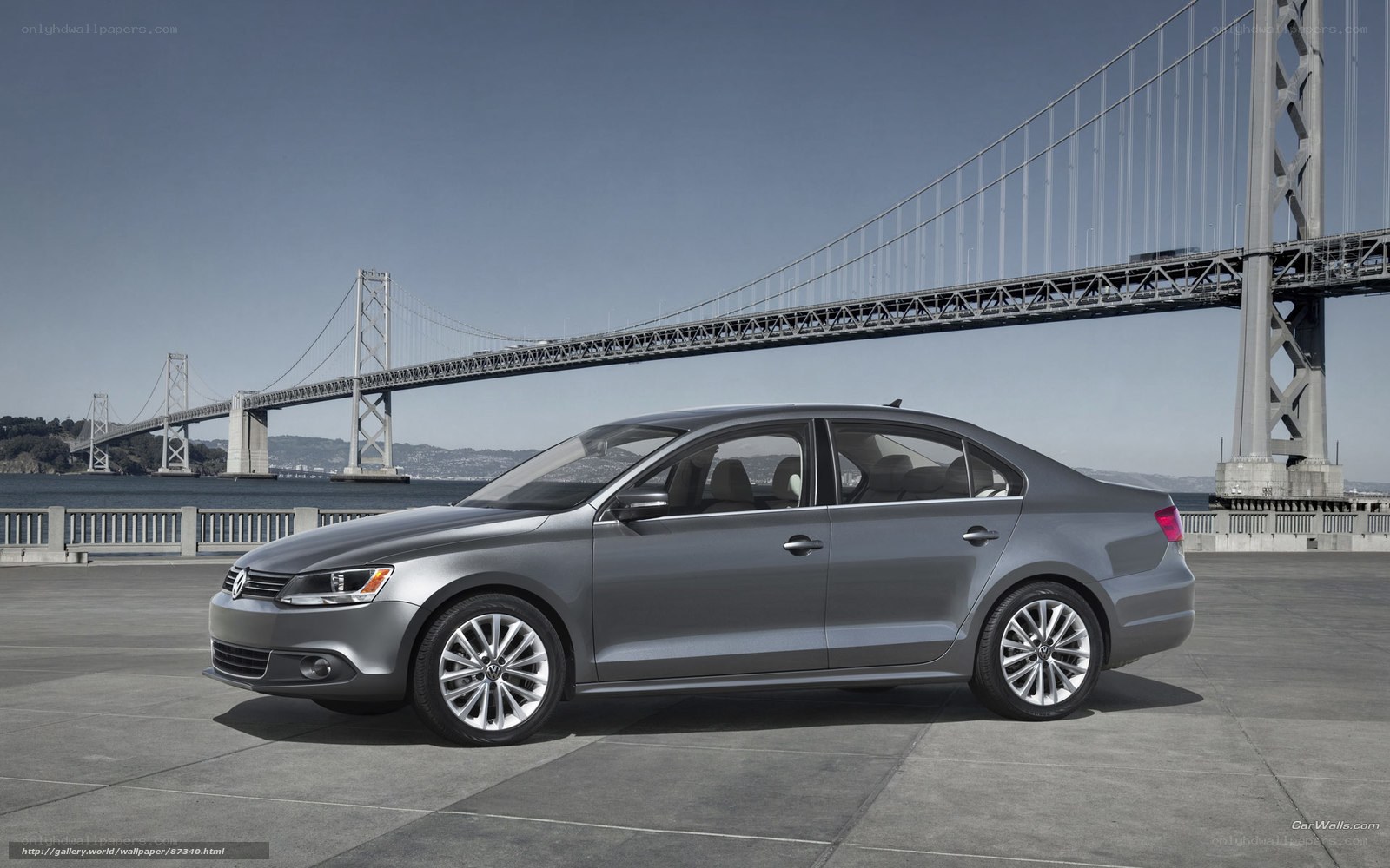 Silver sedan by a bridge