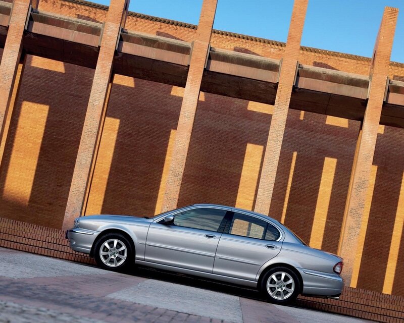 Silver sedan by brick building