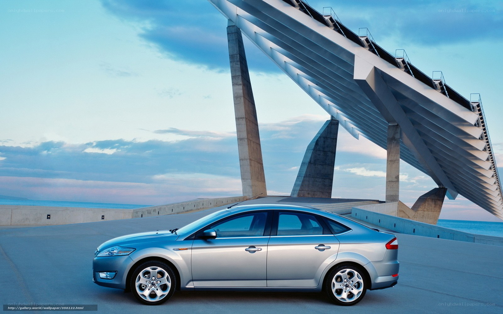Silver sedan by modern bridge