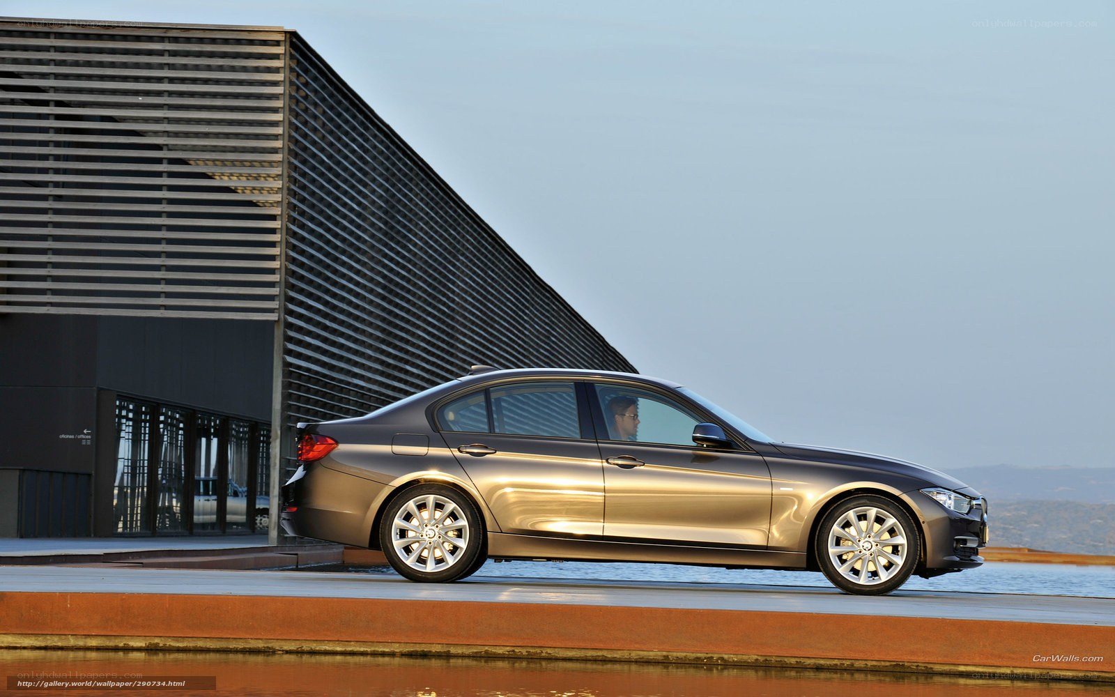 silver sedan by modern building