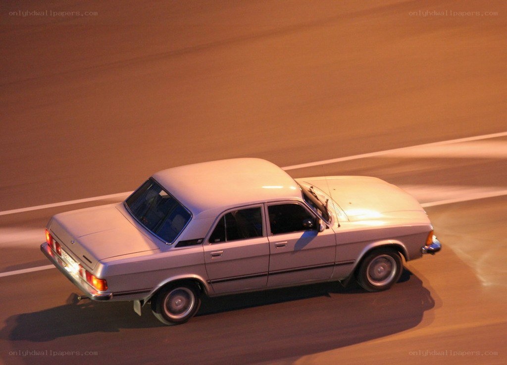silver sedan driving at night