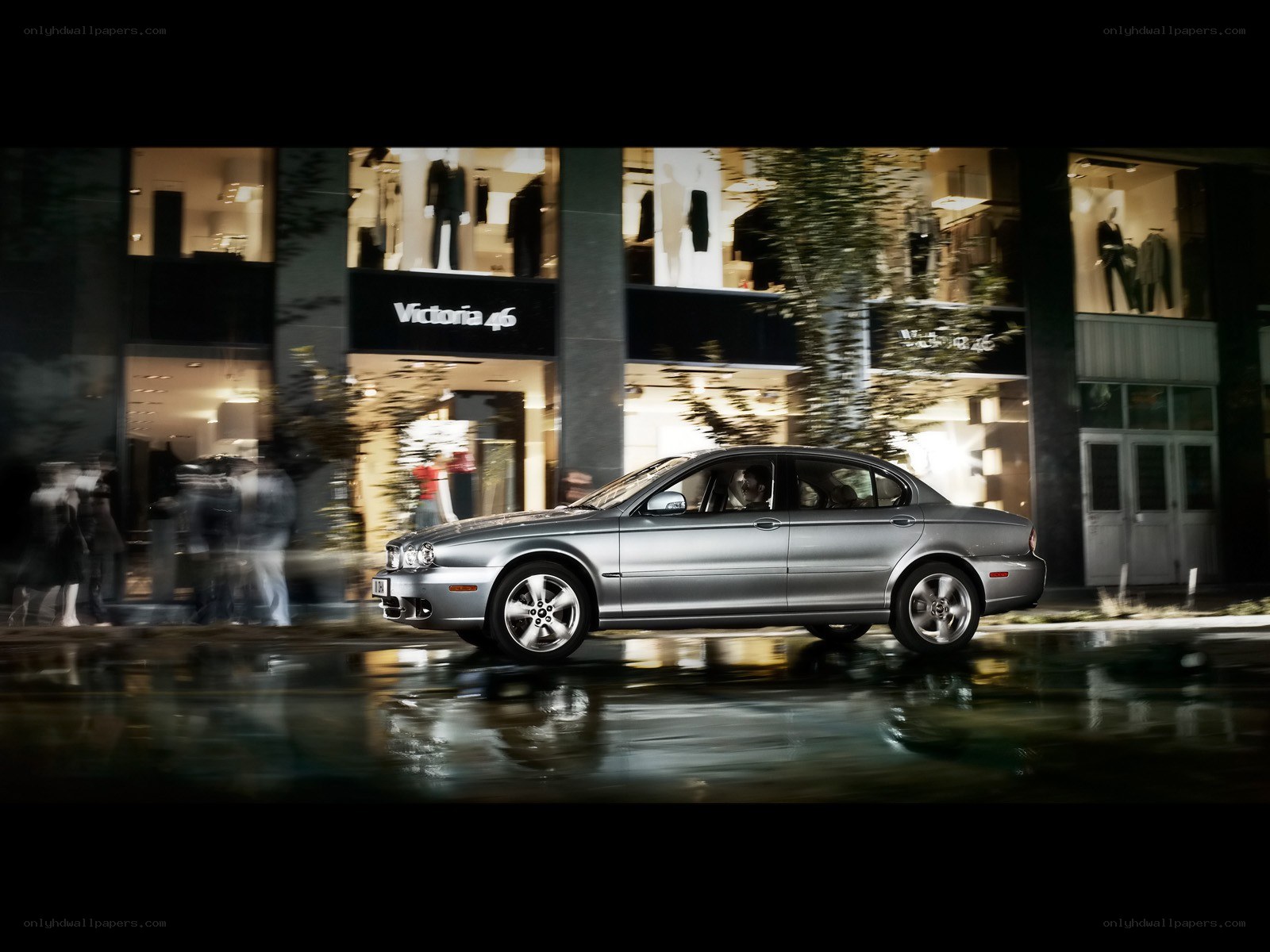 Silver sedan driving at night
