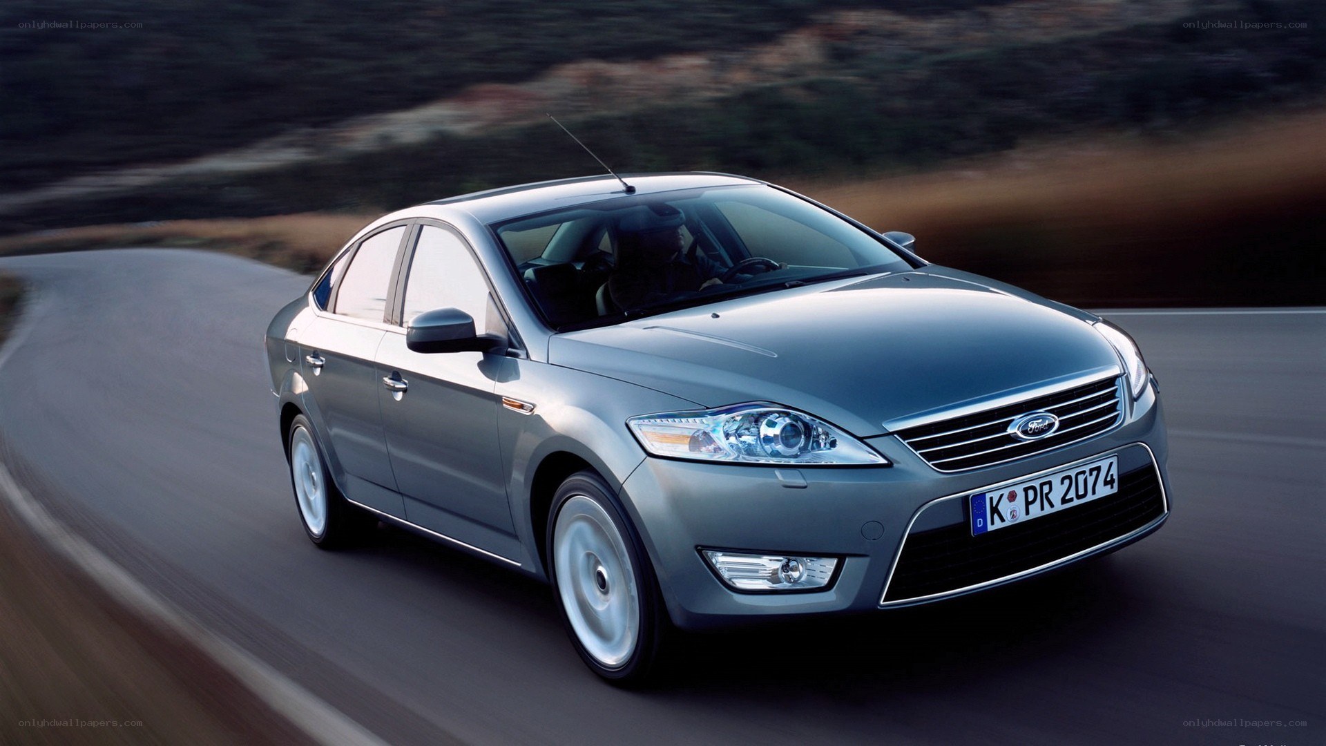 silver sedan driving on road
