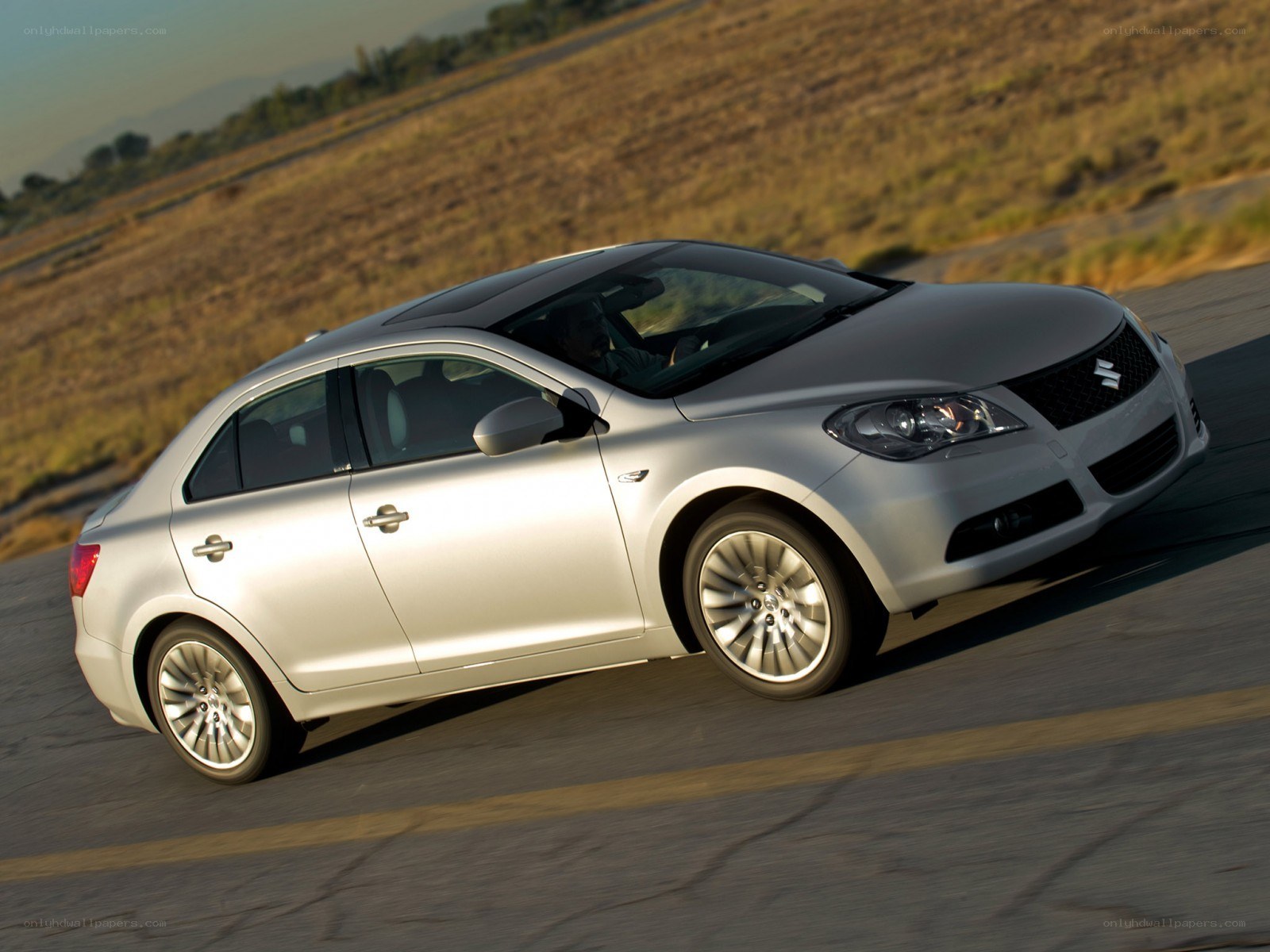 silver sedan driving on road