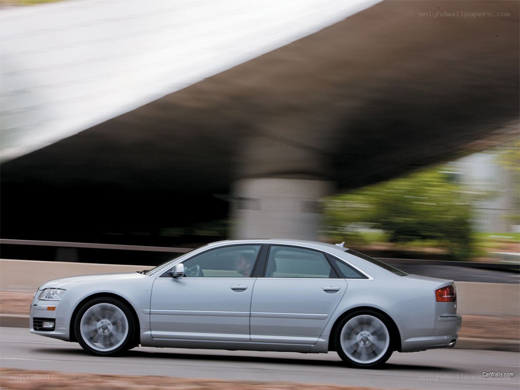 silver sedan driving under overpass