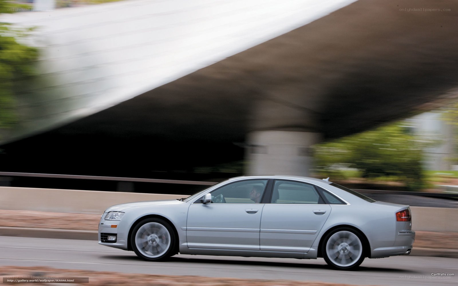 silver sedan driving under overpass