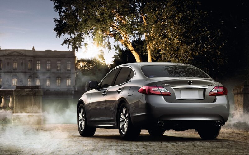 Silver sedan in front of mansion