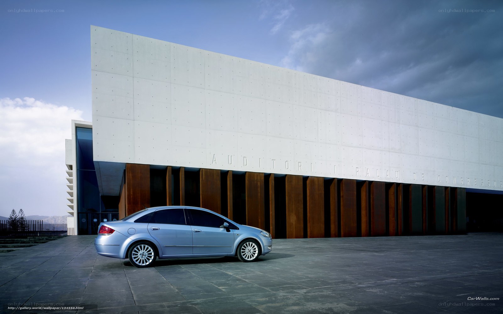 Silver sedan in front of modern building