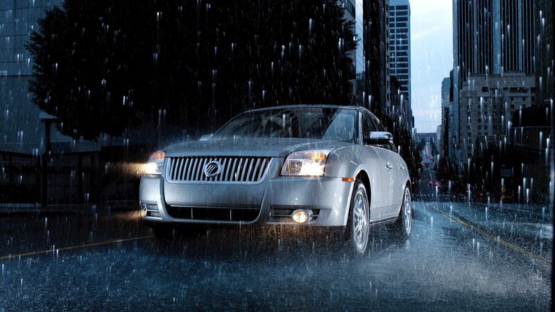 Silver sedan in rainy city