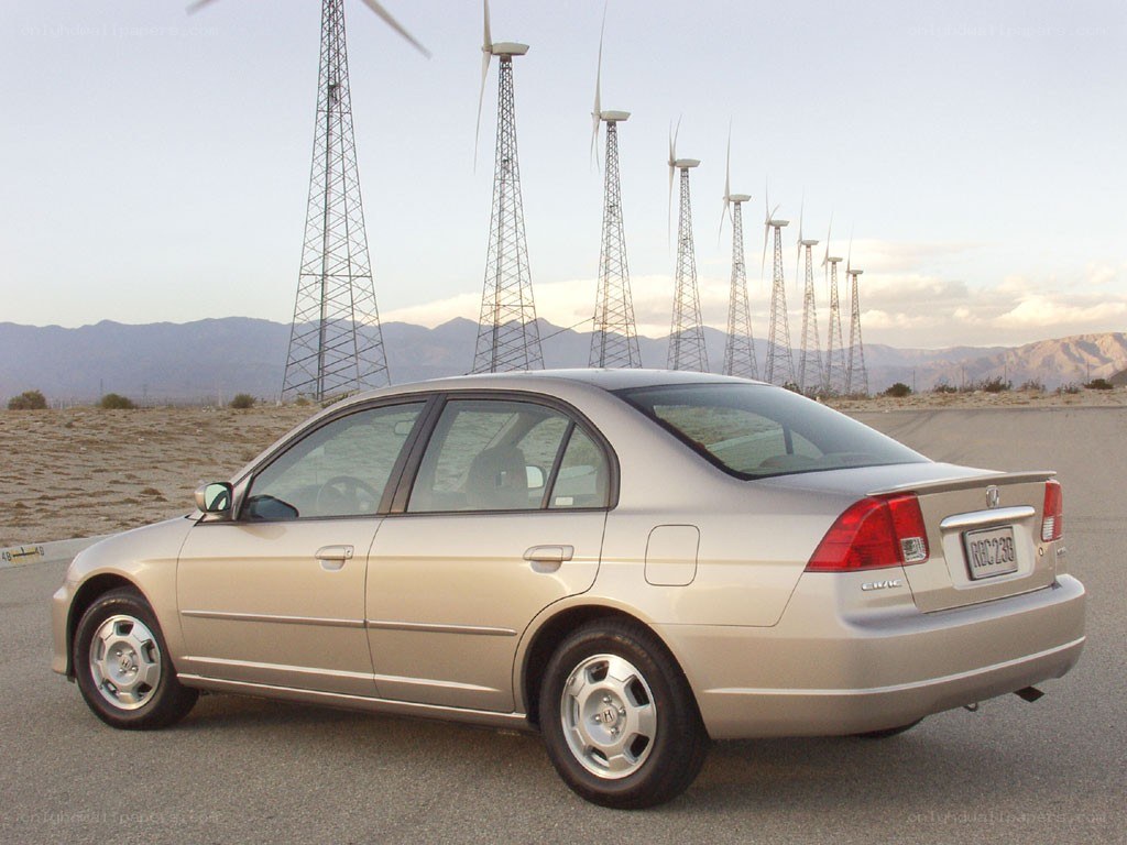silver sedan near wind turbines