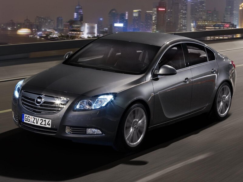 Silver sedan on city bridge