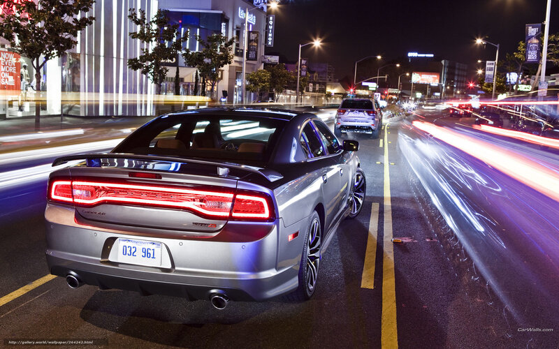Silver sedan on city street at night