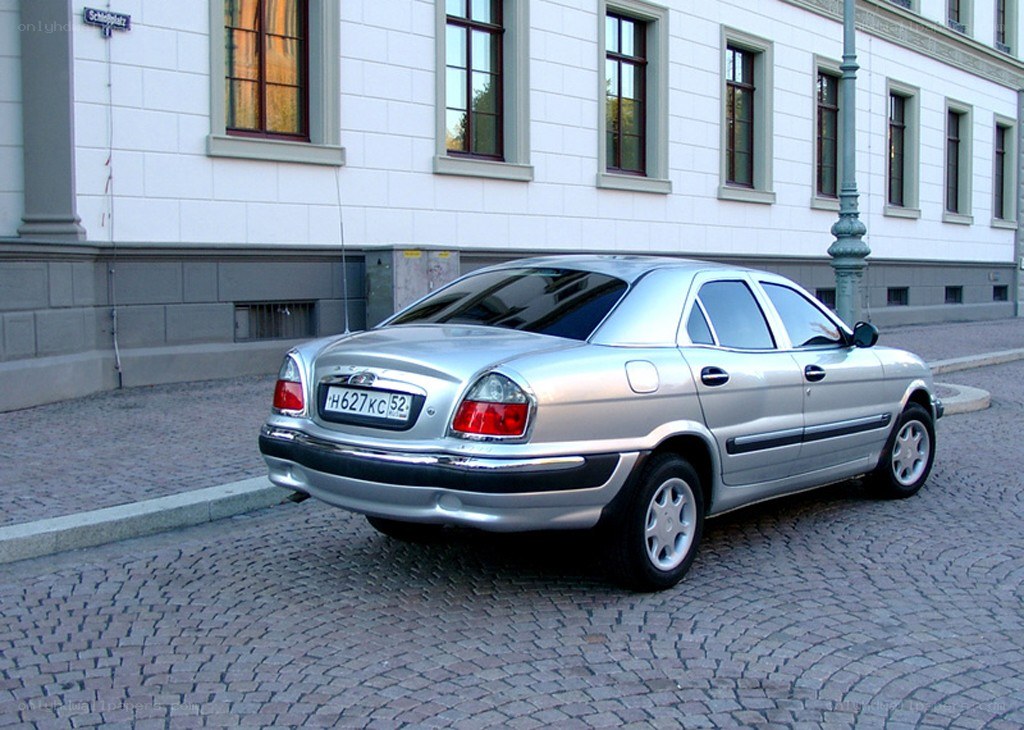 silver sedan on cobblestone street