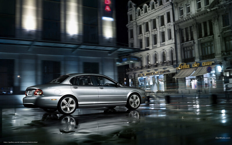 Silver sedan on wet city street