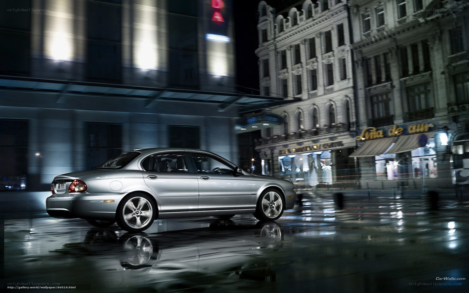 Silver sedan on wet city street