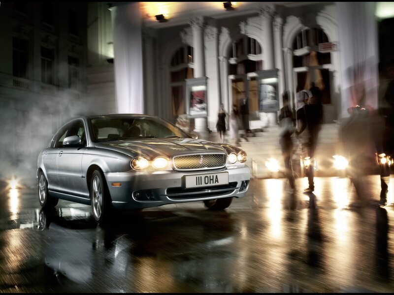 Silver sedan on wet city street