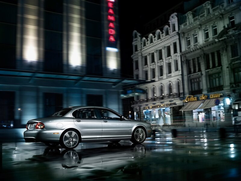 Silver sedan on wet city street