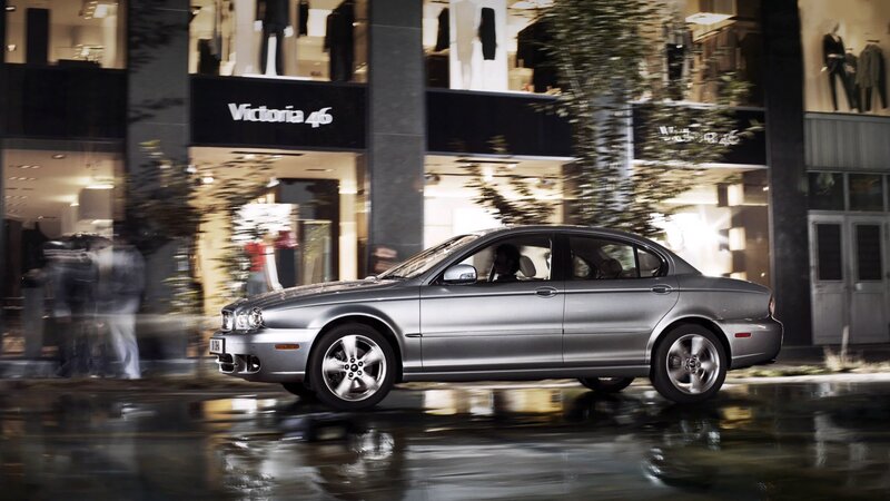 Silver sedan on wet city street