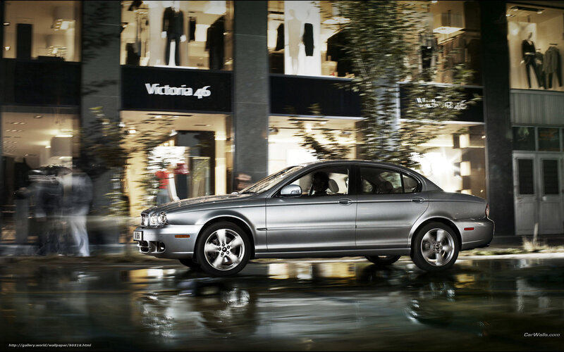 Silver sedan on wet city street