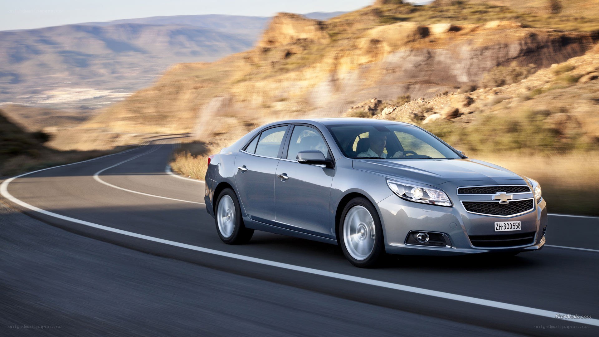 silver sedan on winding road