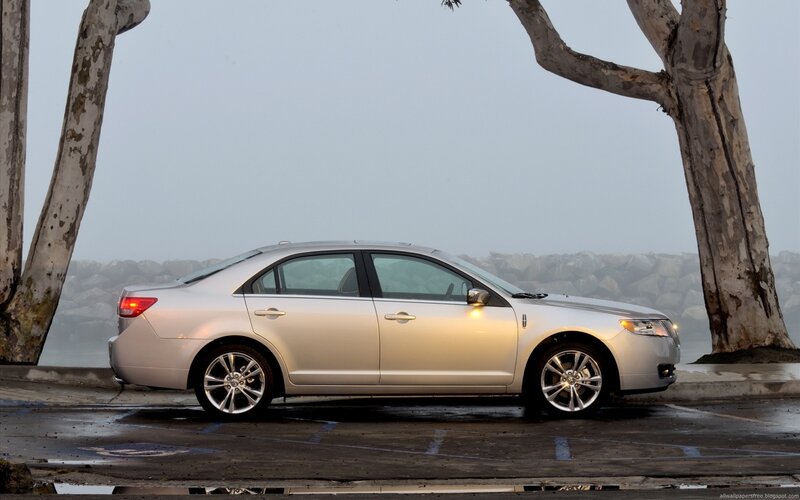 silver sedan parked by trees