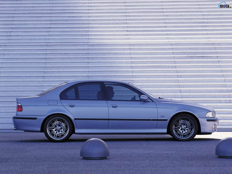silver sedan parked in front of wall