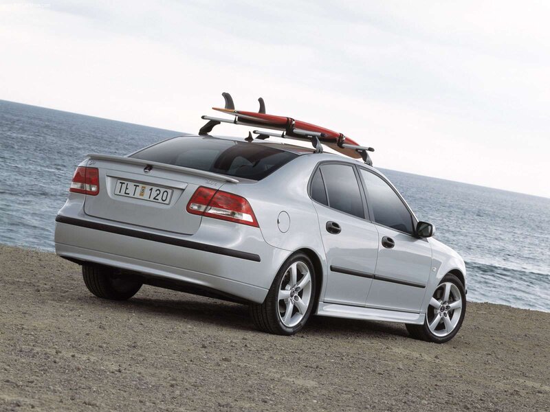 Silver sedan with surfboard on roof