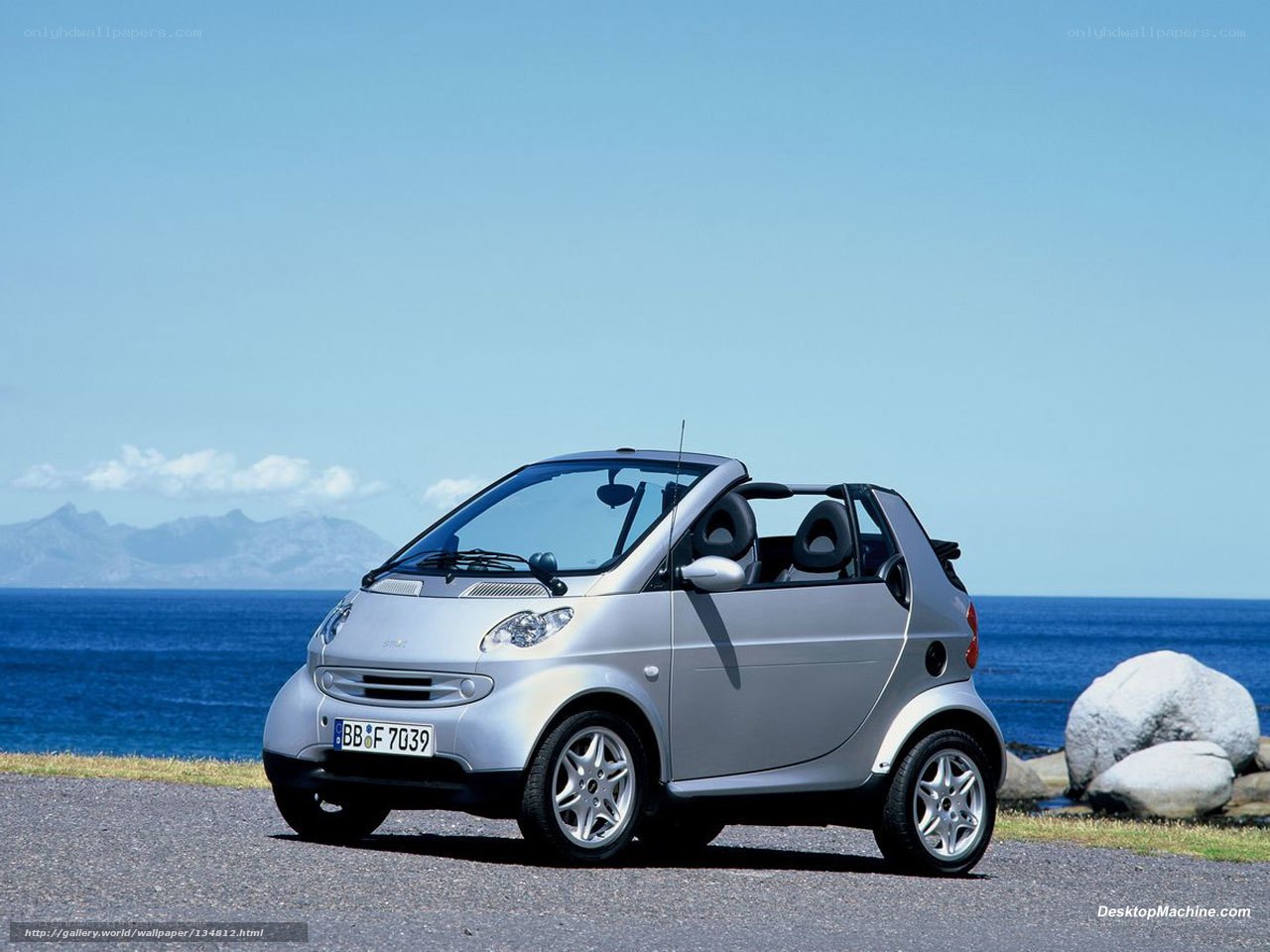 Silver smart car by the sea