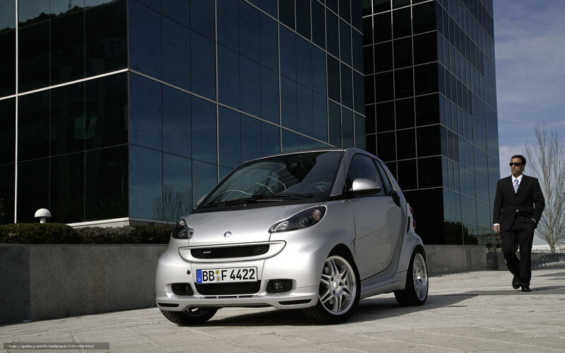 Silver smart car in front of building