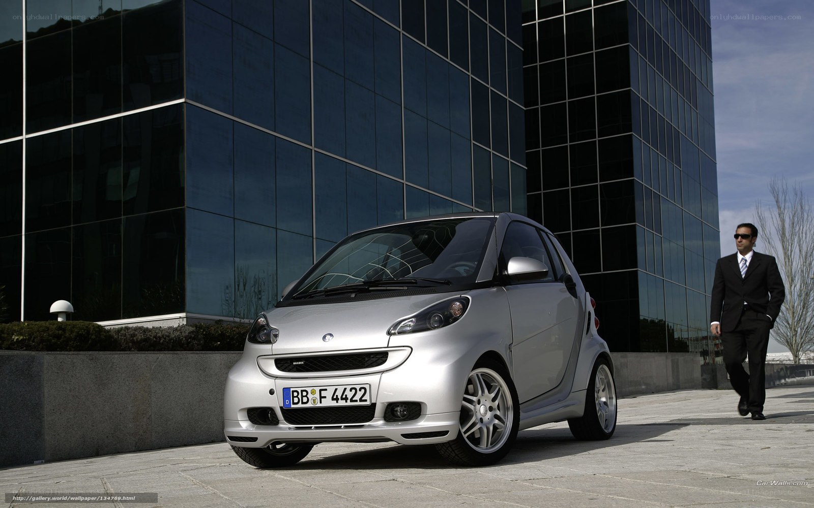 Silver smart car in front of building