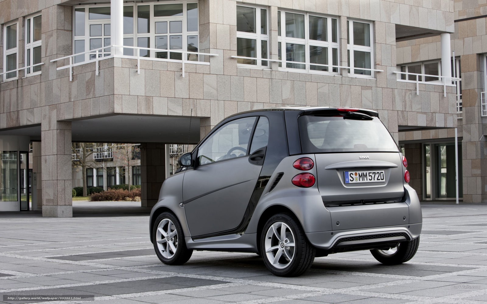 Silver smart car parked outside building