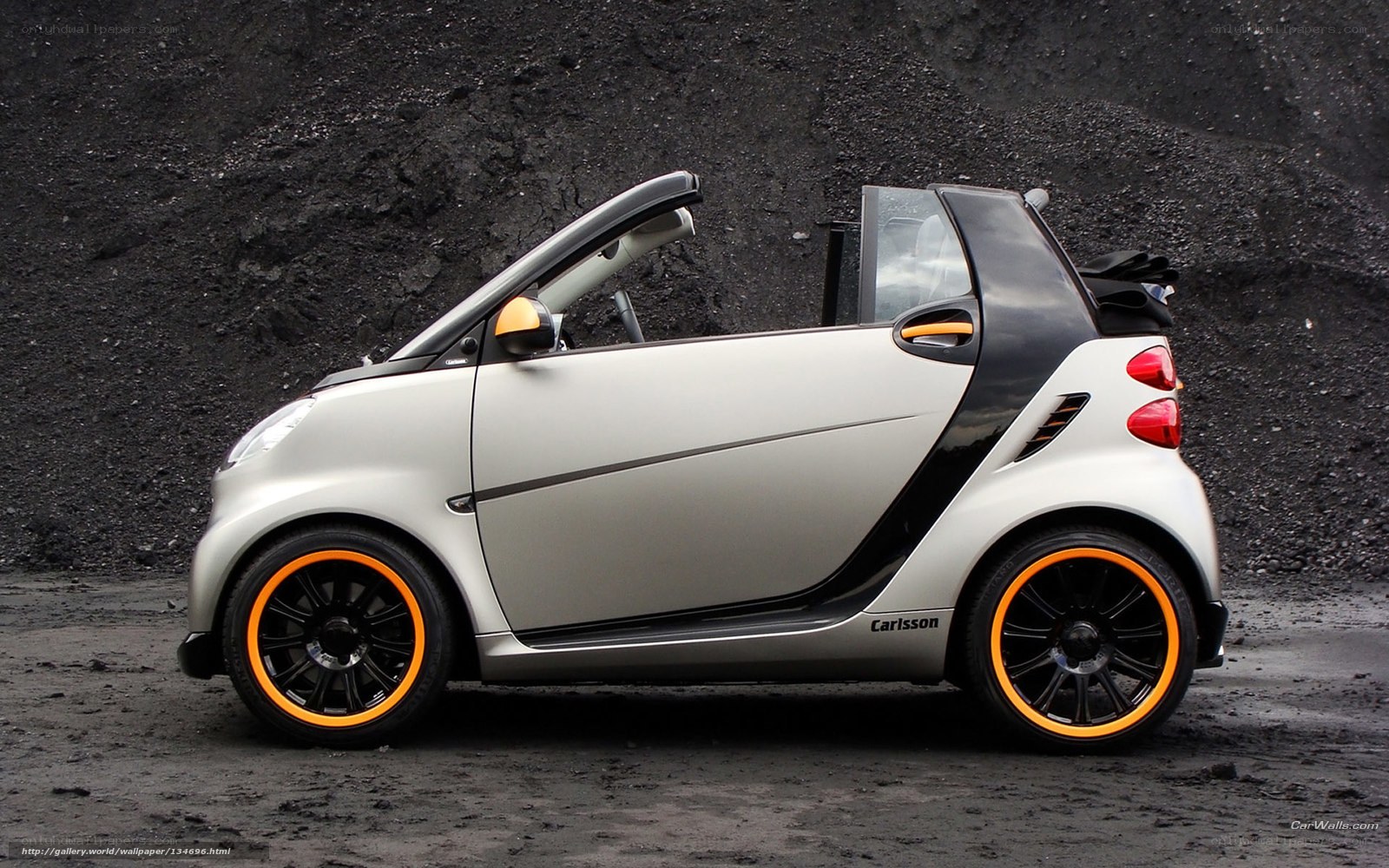 silver smart car with orange rims
