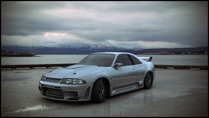 silver sports car by the water