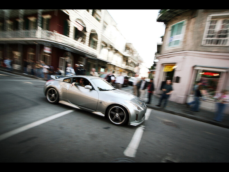 Silver sports car driving through city street