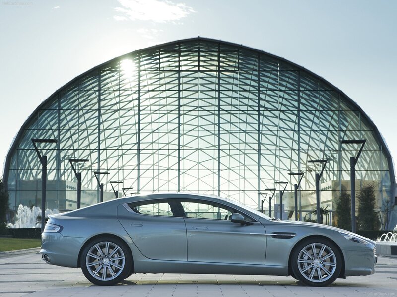 silver sports car in front of glass building