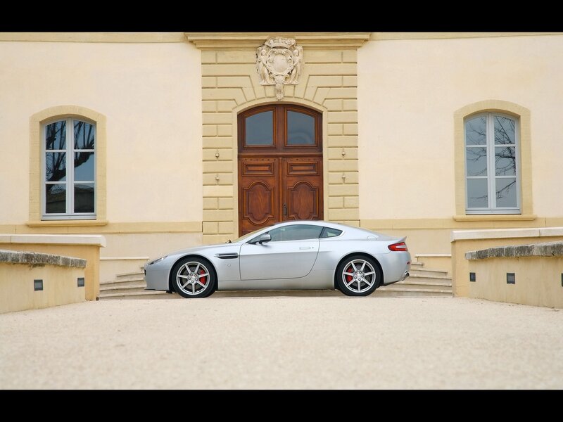 Silver sports car in front of mansion