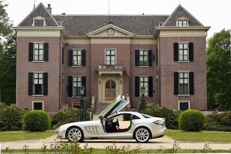 Silver sports car in front of mansion