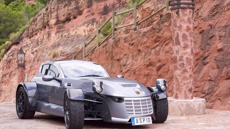 Silver sports car on a cliffside road