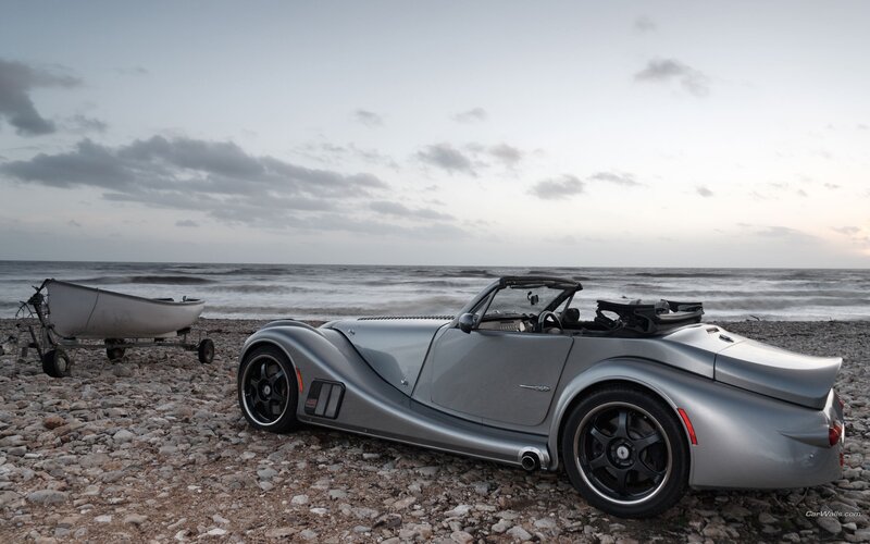 Silver sports car on a pebble beach